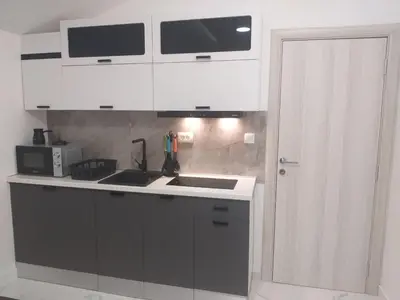 a kitchen with white cabinets and a sink at Studio 033 in Budva