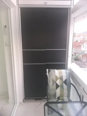 a black closet with a chair and a window at Studio 033 in Budva