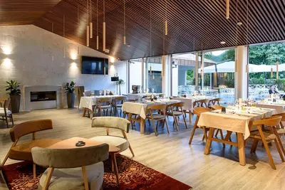 a restaurant with tables and chairs and a fireplace at Hotel Gradska Cetinje in Cetinje