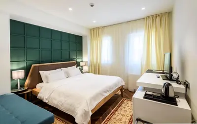 a bedroom with a bed and a desk with a telephone at Hotel Gradska Cetinje in Cetinje