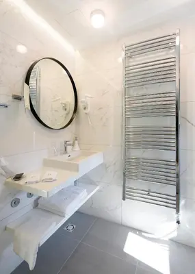 a white bathroom with a sink and a mirror at Hotel Gradska Cetinje in Cetinje