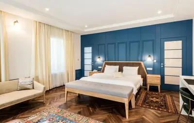a bedroom with blue walls and a bed and a couch at Hotel Gradska Cetinje in Cetinje