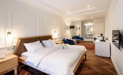 a bedroom with a large white bed in a room at Hotel Gradska Cetinje in Cetinje