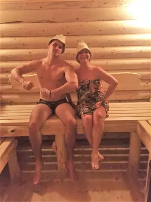 a man and woman sitting on a bench in a sauna at Eko Apartmani Krackovic in Podgorica