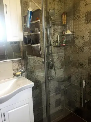 a shower with a glass door next to a sink at Eko Apartmani Krackovic in Podgorica