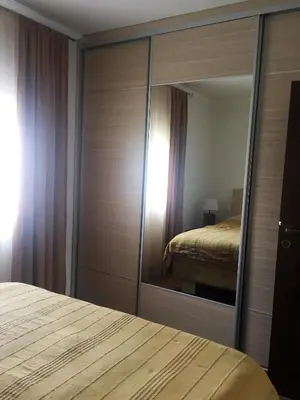 a bedroom with a large mirror and a bed at Eko Apartmani Krackovic in Podgorica