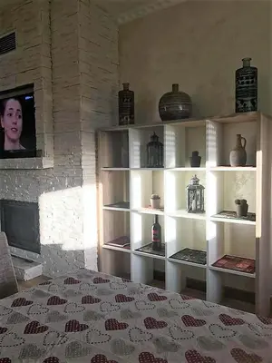 a room with a wall with shelves with vases at Eko Apartmani Krackovic in Podgorica