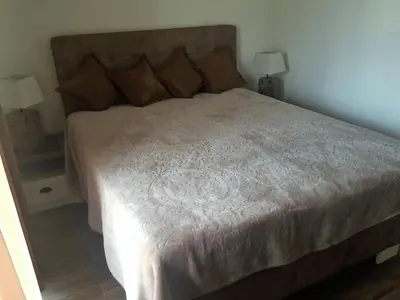 a bed in a bedroom with two lamps on tables at Eko Apartmani Krackovic in Podgorica