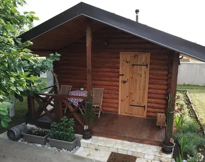 a wooden cabin with a table and chairs in it at Eko Apartmani Krackovic in Podgorica