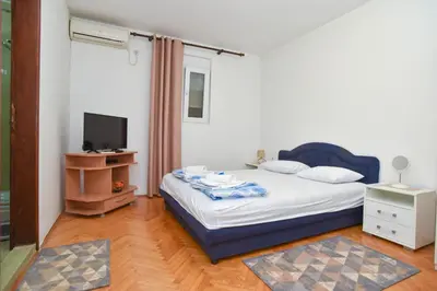a bedroom with a bed and a television in it at Apartment Senka in Budva