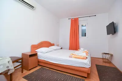 a small bedroom with a bed and a tv at Apartment Senka in Budva