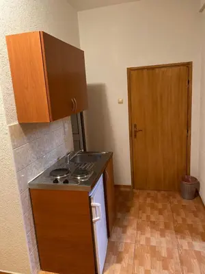 a kitchen with a stove and a wooden cabinet at Apartments Toni in Ulcinj