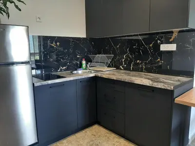 a kitchen with blue cabinets and a stainless steel refrigerator at Đuričić Apartmani in Budva