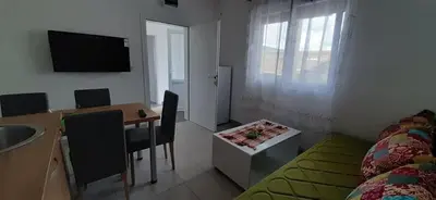 a small room with a table and a bed and a desk at Đuričić Apartmani in Budva