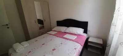 a bedroom with a bed with a pink and white blanket at Đuričić Apartmani in Budva