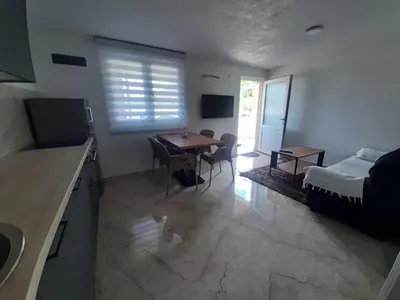 a kitchen and living room with a table and a bed at Đuričić Apartmani in Budva