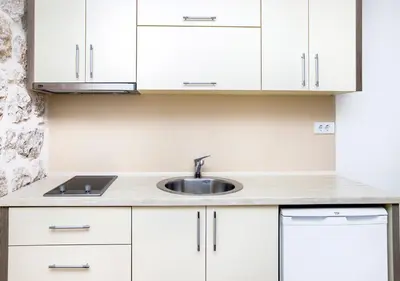 a kitchen with white cabinets and a sink at Apartments Mezini 11 in Kotor