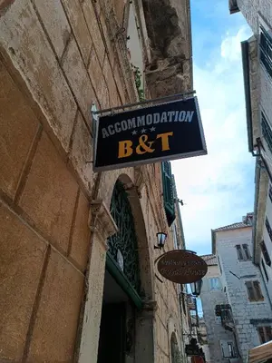 a sign for a restaurant on the side of a building at Nova dvokrevetna soba sa dva odvojena kreveta i zajedničkim kupatilom in Kotor