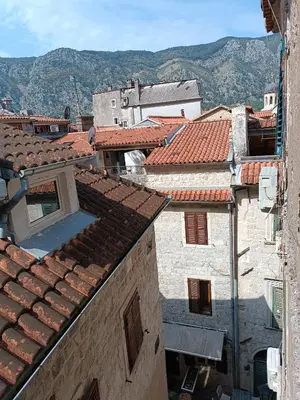 a view of roofs of buildings with mountains in the background at Nova dvokrevetna soba sa dva odvojena kreveta i zajedničkim kupatilom in Kotor
