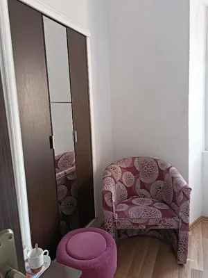 a room with a pink chair and a mirror at Nova dvokrevetna soba sa dva odvojena kreveta i zajedničkim kupatilom in Kotor