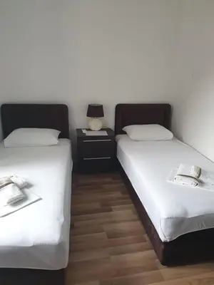 two beds sitting next to each other in a room at Nova dvokrevetna soba sa dva odvojena kreveta i zajedničkim kupatilom in Kotor