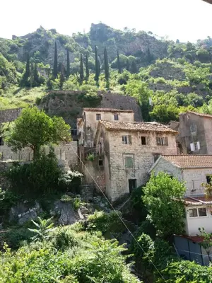 an old village on a hill with trees and buildings at Nova dvokrevetna soba sa dva odvojena kreveta i zajedničkim kupatilom in Kotor