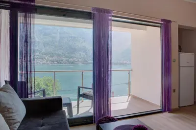 a living room with a large window with purple curtains at Fortress View apartment in Kotor