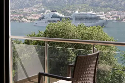 a balcony with a view of a cruise ship in the water at Fortress View apartment in Kotor
