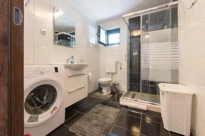 a bathroom with a washing machine and a sink at Fortress View apartment in Kotor