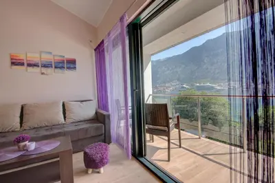 a living room with a couch and a balcony at Fortress View apartment in Kotor