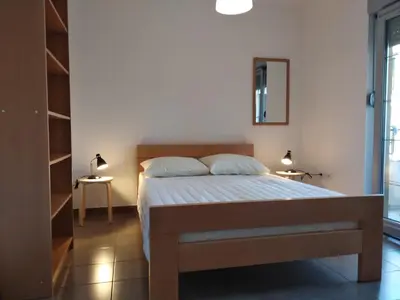 a bedroom with a bed and a mirror on the wall at Studio Alexandra in Petrovac na Moru