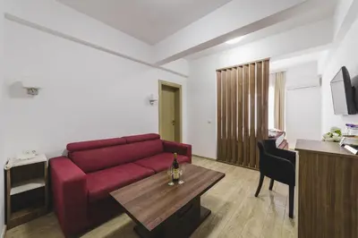 a living room with a red couch and a table at Hotel 219 Budva in Budva