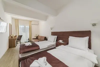 a hotel room with two beds and a couch at Hotel 219 Budva in Budva