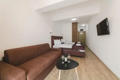 a living room with a couch and a bed at Hotel 219 Budva in Budva