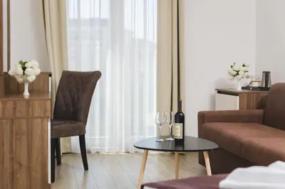 a living room with a bottle of wine and a chair at Hotel 219 Budva in Budva