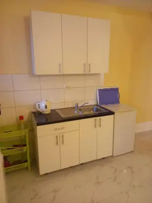 a kitchen with white cabinets and a sink at Bungalo Đeković in Ulcinj