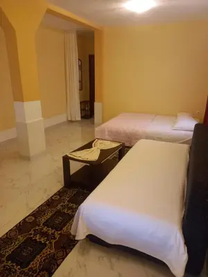 a hotel room with two beds and a table at Bungalo Đeković in Ulcinj