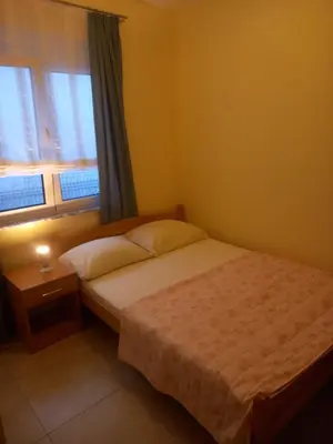 a bedroom with a bed and a window at Bungalo Đeković in Ulcinj