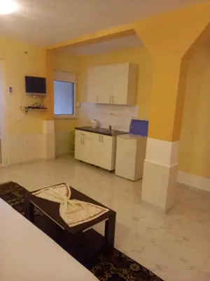 a room with a kitchen with a table and a chair at Bungalo Đeković in Ulcinj