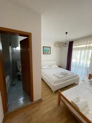 a hotel room with two beds and a mirror at Apartments Dibra in Ulcinj