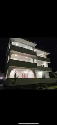 a large white building with lights on it at night at Apartments Dibra in Ulcinj