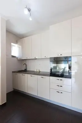 a kitchen with white cabinets and a sink at ENA Apartment in Kotor