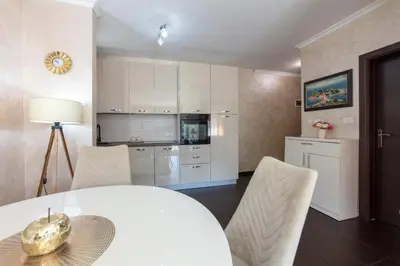 a kitchen and dining room with a white table and chairs at ENA Apartment in Kotor