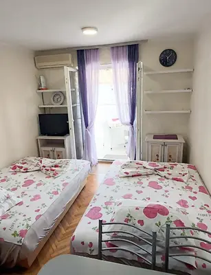 a bedroom with two beds and a window at Sunčani apartman 1-Vila Amfora in Budva