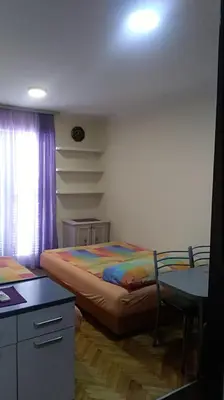 a bedroom with a bed and a desk and a table at Sunčani apartman 1-Vila Amfora in Budva