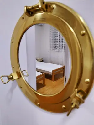 a gold mirror with a bed in a room at Podgorica Center in Podgorica