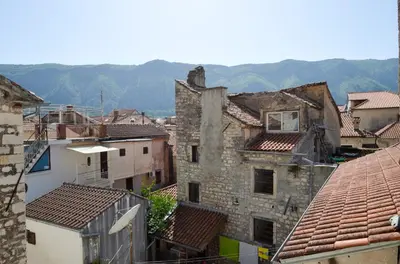a group of buildings with mountains in the background at Portobello Old Town in Kotor