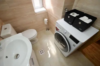 a bathroom with a toilet and a washing machine at Portobello Old Town in Kotor