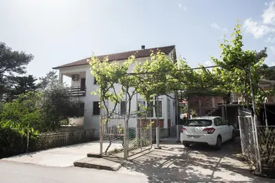 a white car parked in front of a house at Stojkovic Family Apartments in Tivat