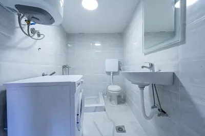 a white bathroom with a sink and a toilet at Stojkovic Family Apartments in Tivat